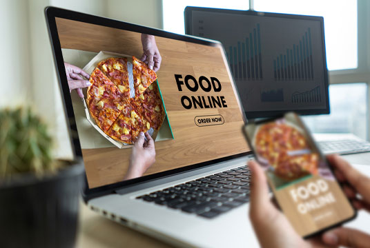 DBS Point of Sale Online Ordering Online food ordering with pizza on laptop and smartphone screens.