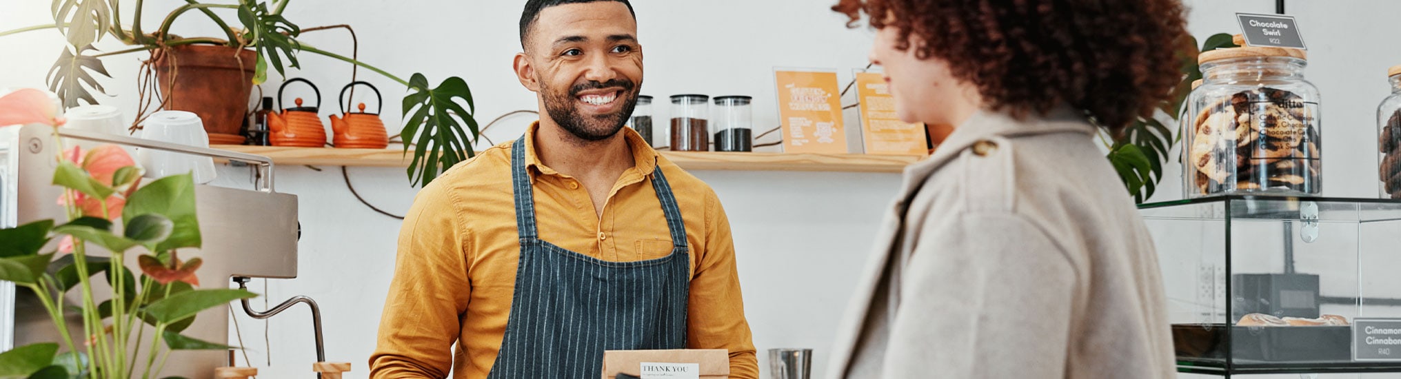 A friendly cashier checking out a customer in a retail store.