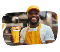 Smiling vendor holding French fries in a kitchen.