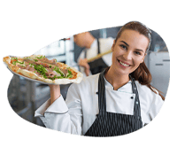 Smiling waitress holding a pizza in a restaurant setting.