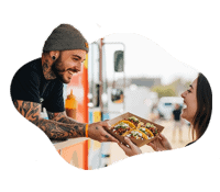 Happy customer receiving food with a smile from a food truck vendor.